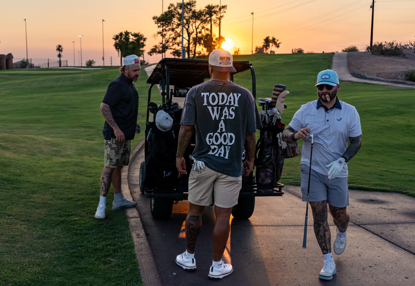 Three friends at the cart at sunset, one in a “Today was a good day” shirt